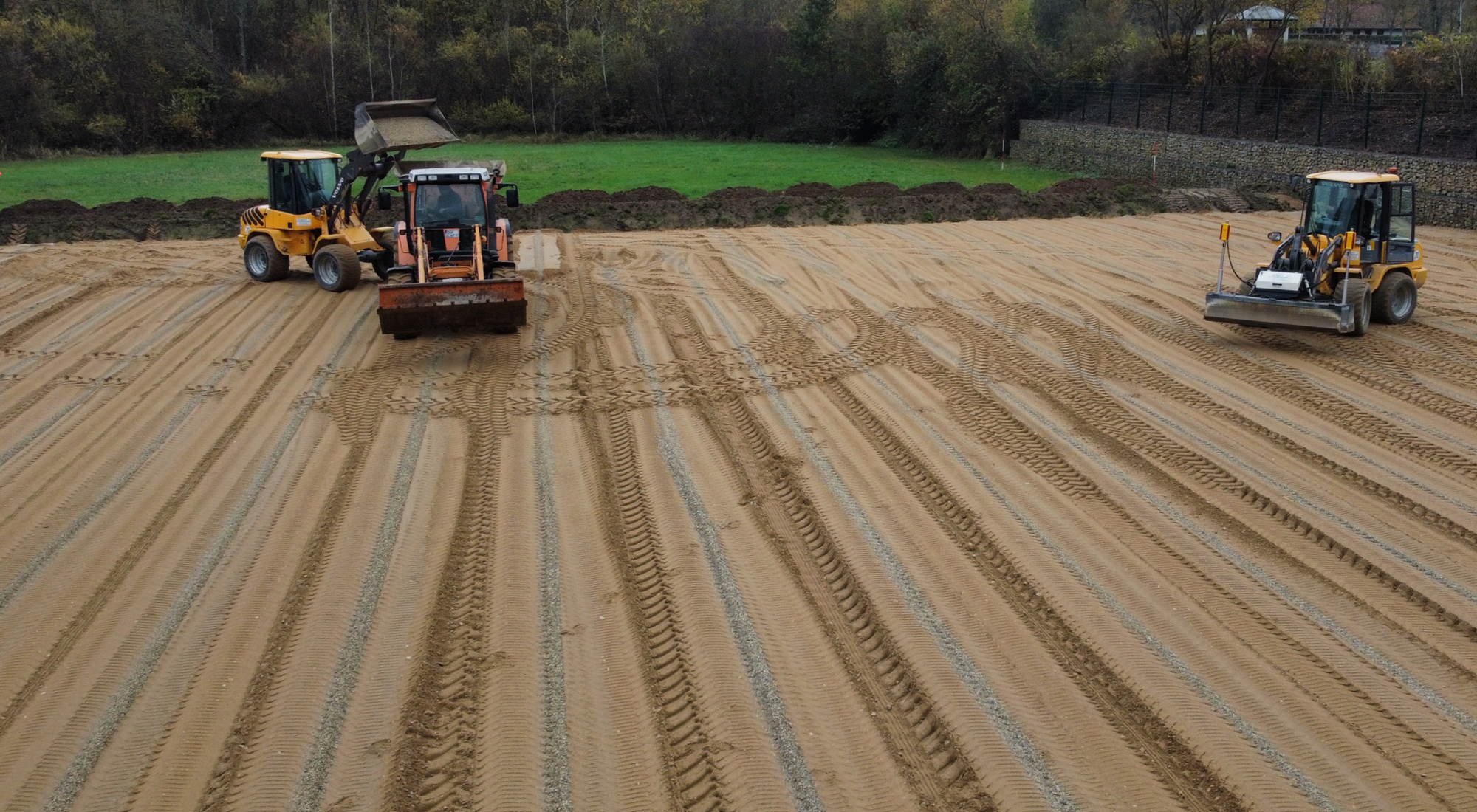 Einbau von Drainageschlitzen im Sportrasenplatz zur schnellen Ableitung von Oberflächenwasser und Vermeidung von Staunässe.